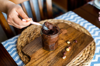 Midsection of person holding ice cream cone on table