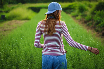 Rear view of woman standing on field