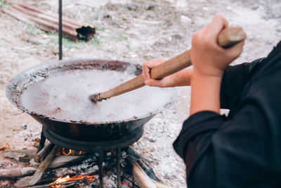 Cropped image of person preparing food on barbecue grill