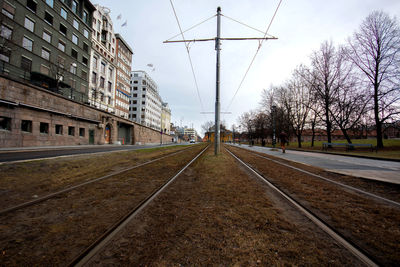 Railroad tracks in city against sky