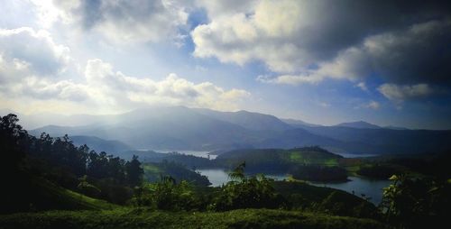 Scenic view of river and mountains against cloudy sky