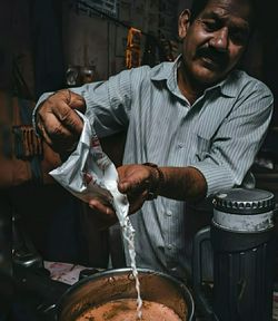 Young man making tea in workshop