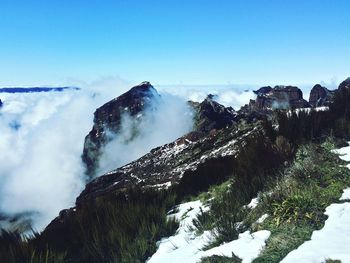 Scenic view of mountains against blue sky