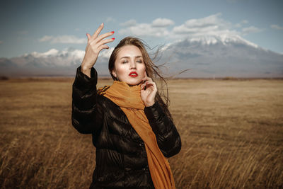 Portrait of young woman standing in field
