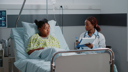 Portrait of doctor examining patient in gym