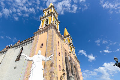 Low angle view of clock tower amidst buildings against sky