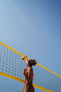 Woman with afro hair playing beach volleyball