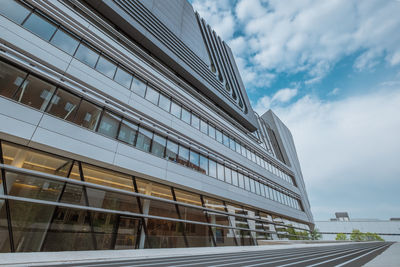 Low angle view of modern building against cloudy sky