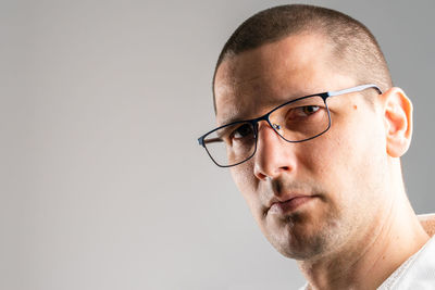 Portrait of man wearing eyeglasses against white background