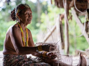 Side view of woman sitting outdoors