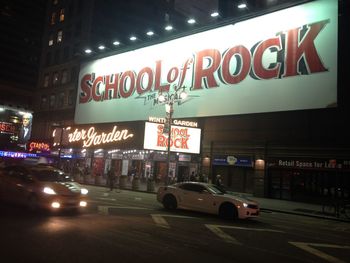 Information sign on road in city at night