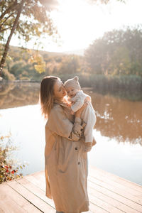 Smiling young mother playing with baby boy 1 year old wear casual clothes over nature background