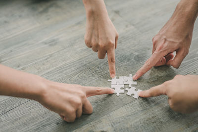 Midsection of people playing with ball on table