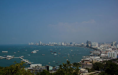 High angle view of city by sea against sky