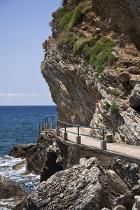Rock formation on beach against sky