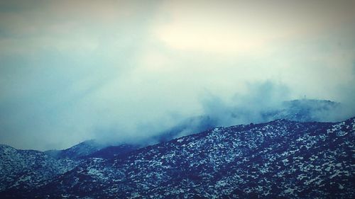 Scenic view of mountains against cloudy sky