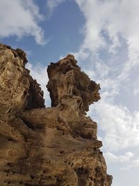 Low angle view of rock formation against sky