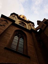 Low angle view of historic church against cloudy sky