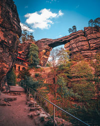Scenic view of rock formation amidst trees against sky