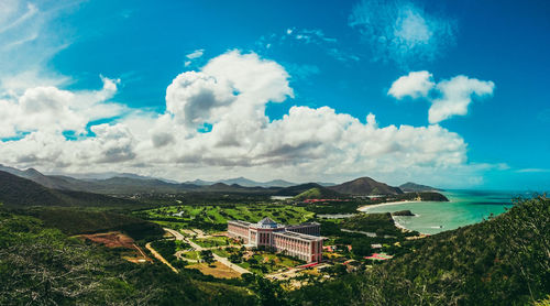 Panoramic view of buildings and mountains against blue sky