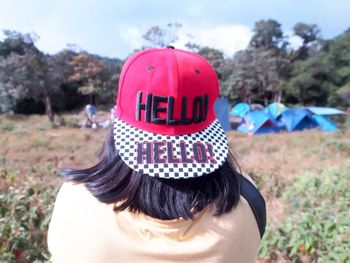 Rear view of woman wearing baseball cap with hello text
