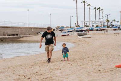 Father and child walking along the beach