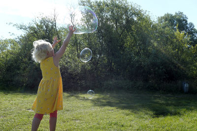 Germany, schleswig holstein, heidkate, child playing with soap bubbles