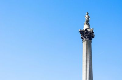 Low angle view of statue against blue sky