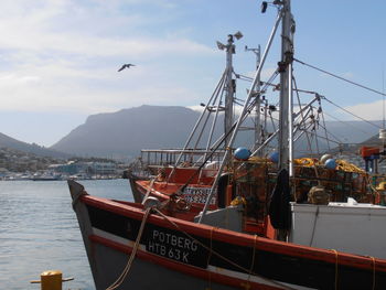 Boats moored in calm sea against sky