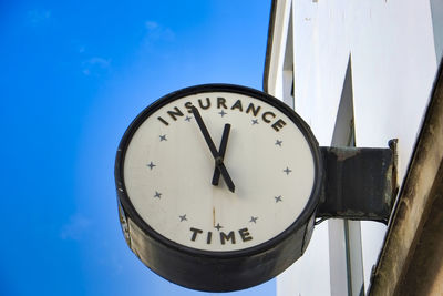 Low angle view of clock against sky