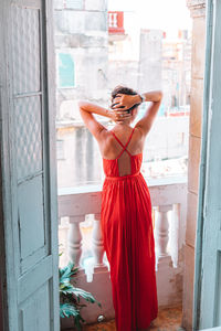 Rear view of woman standing by window