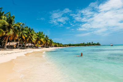 Scenic view of people on beach against sky