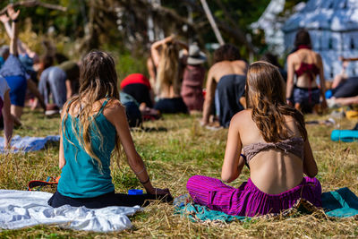 Rear view of women sitting on field