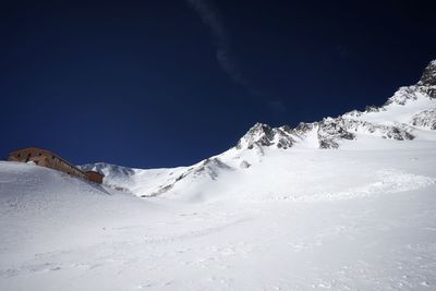 Snow covered mountain against blue sky