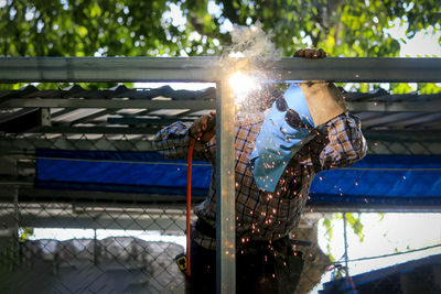 Low angle view of illuminated lighting equipment against sky