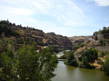 Scenic view of river amidst trees against sky