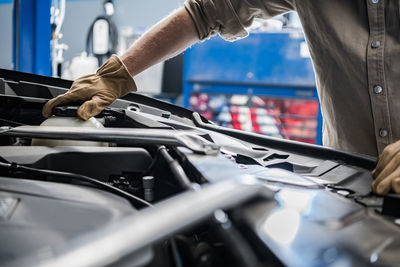 Midsection of man repairing car