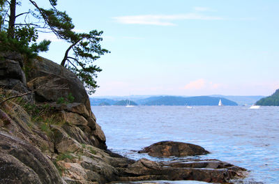 Rock formations in sea against sky