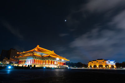 Illuminated buildings against sky at night