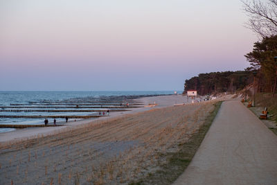 Scenic view of beach against clear sky during sunset