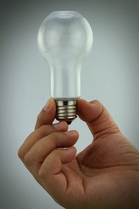 Close-up of hand holding light bulb