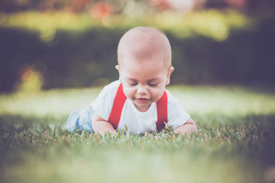 Portrait of cute boy lying on grass