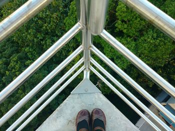 Low section of woman standing by railings