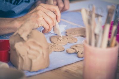 Midsection of man holding hands on table