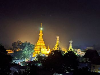 Illuminated buildings against sky at night