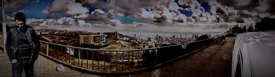 Panoramic view of buildings against cloudy sky