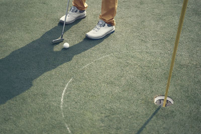 Low section of person standing on golf course