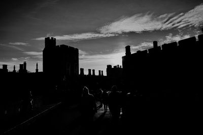 Silhouette buildings against sky at sunset