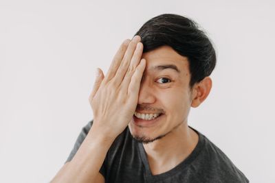 Portrait of young woman against white background