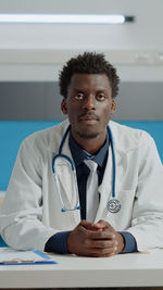 Portrait of doctor examining patient in clinic